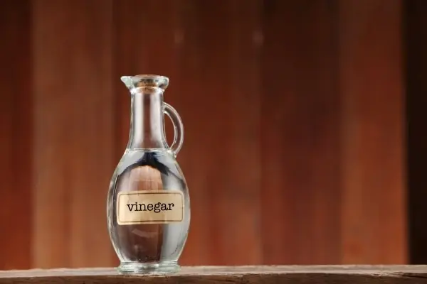 Botella de vinagre de vino blanco en una superficie de madera