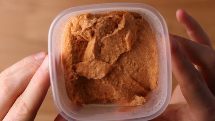 Hummus congelado en un recipiente congelador