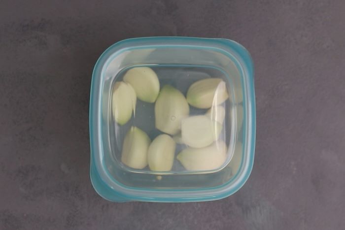 Dientes de ajo en un recipiente listo para congelar