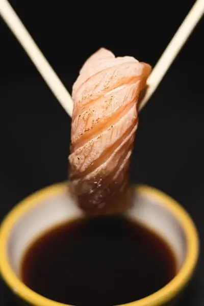 Mojar el sushi en salsa de soja