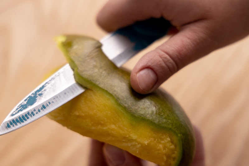 Peel the mango with a knife