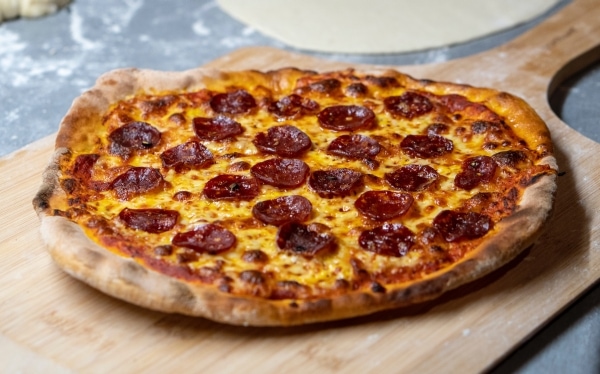 Pizza de pepperoni en una bandeja de madera