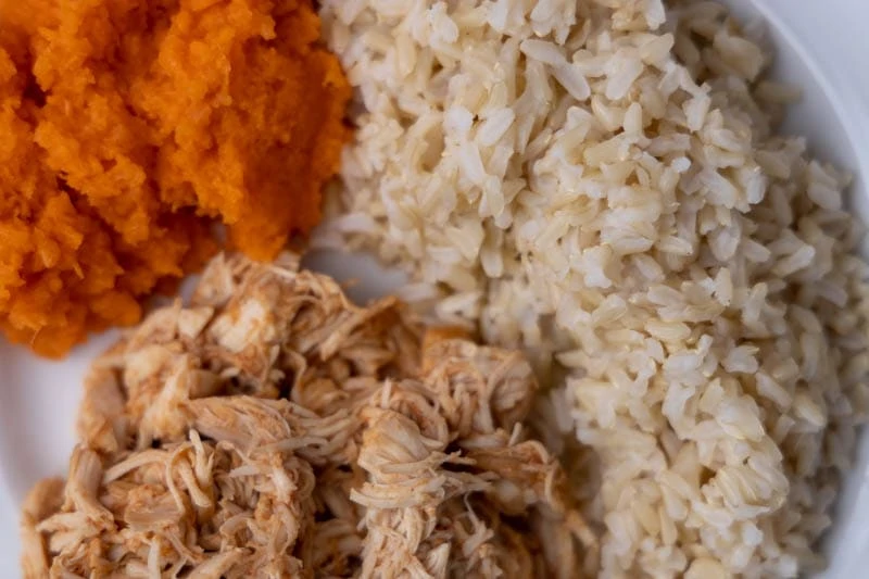 Cena con arroz con pollo a la barbacoa y zanahorias ralladas