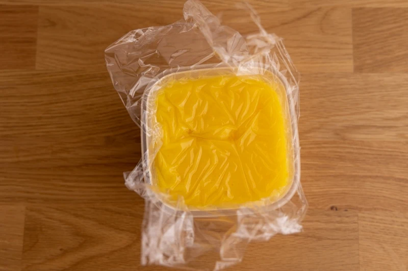 Cuajada de limón tibia cubierta con una envoltura de plástico