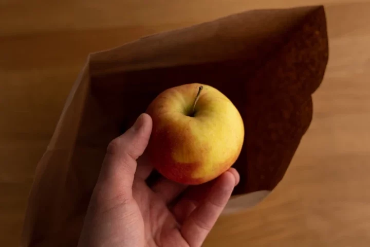 Add apple to brown bag