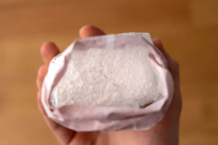 Bolsa de azucar en polvo en la mano