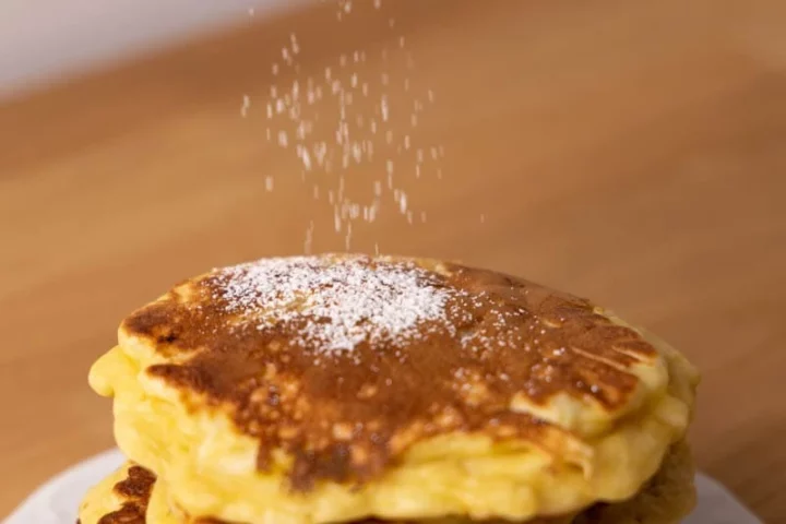 Sprinkle powdered sugar over the pancakes