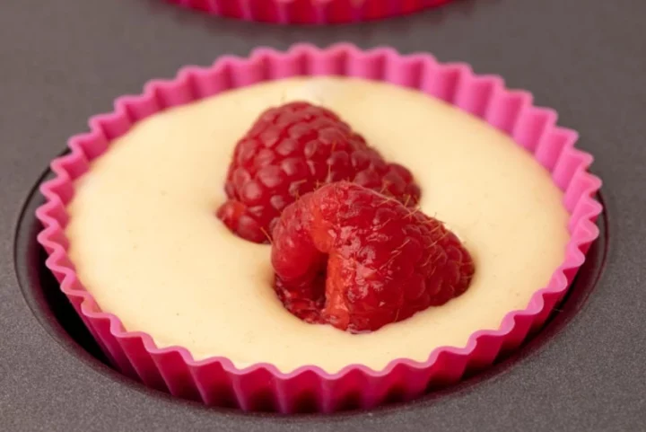 Cupcake batter and two raspberries
