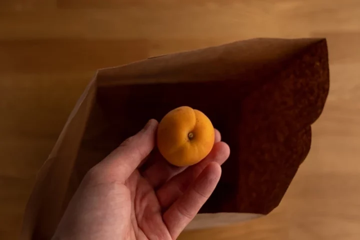 Put apricot in paper bag