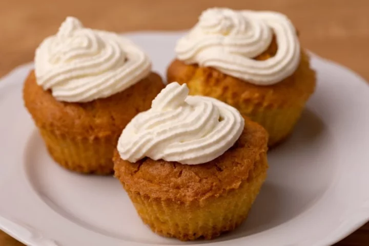 Three glazed cupcakes with whipped cream