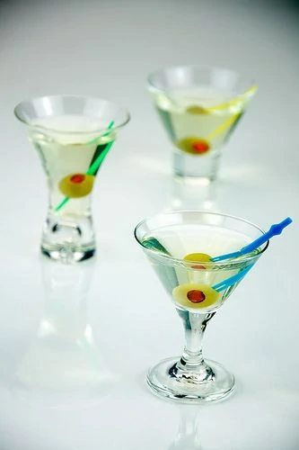 Tres martinis sucios en miniatura servidos con una guarnicion tradicional de aceitunas