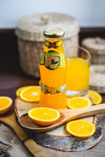 botella de zumo de naranja y naranjas