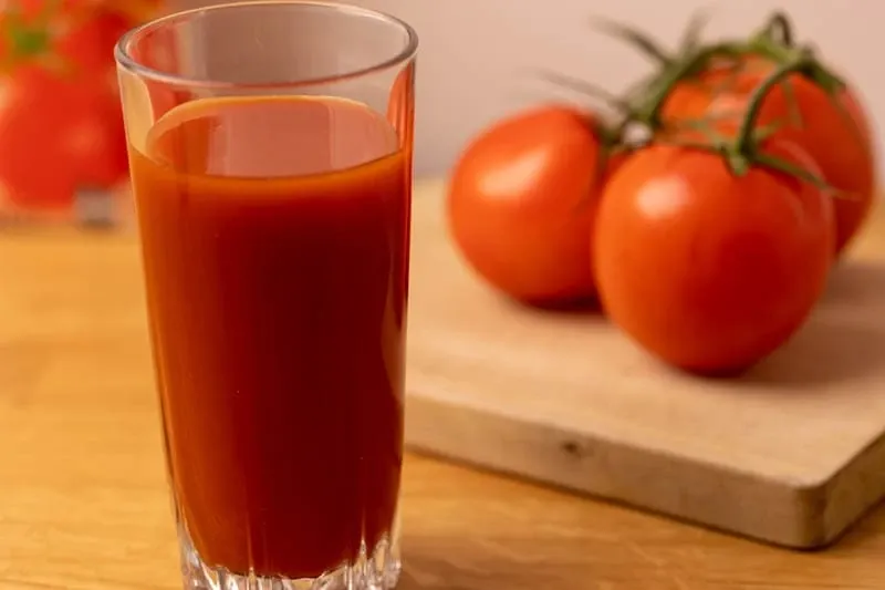 vaso de zumo de tomate y fondo de tomates