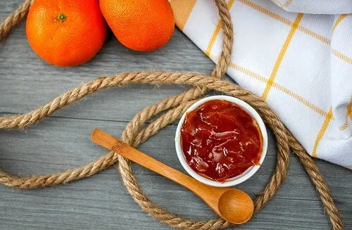 mermelada de naranja con cuchara de madera vista superior